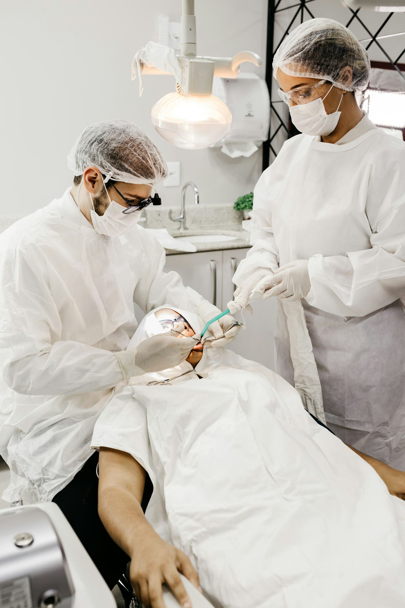 Stock photo: two dentists in protective equipment treating a patient (demo)